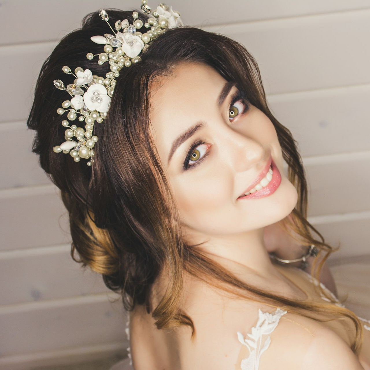 woman with white floral headdress beside white wall