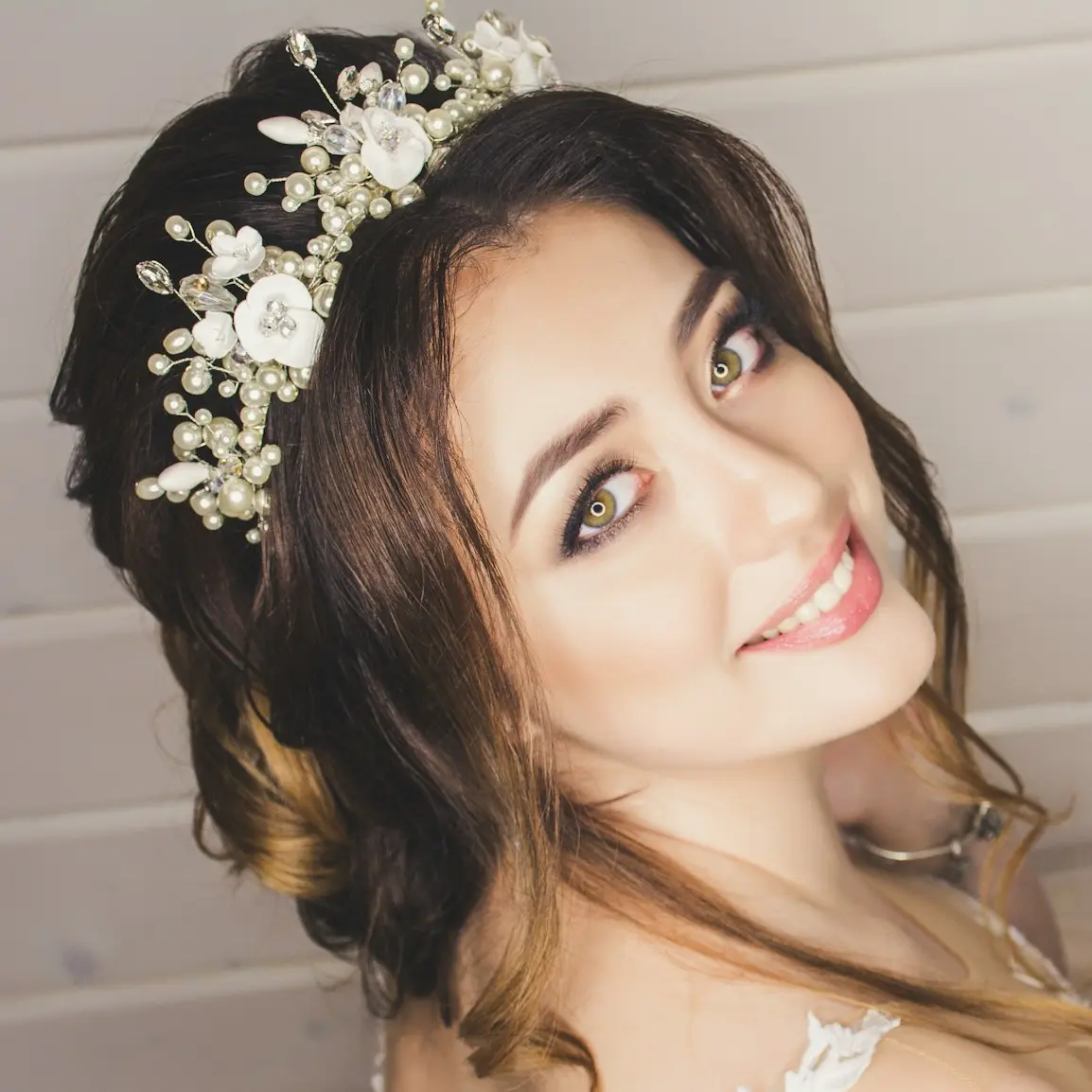 woman with white floral headdress beside white wall